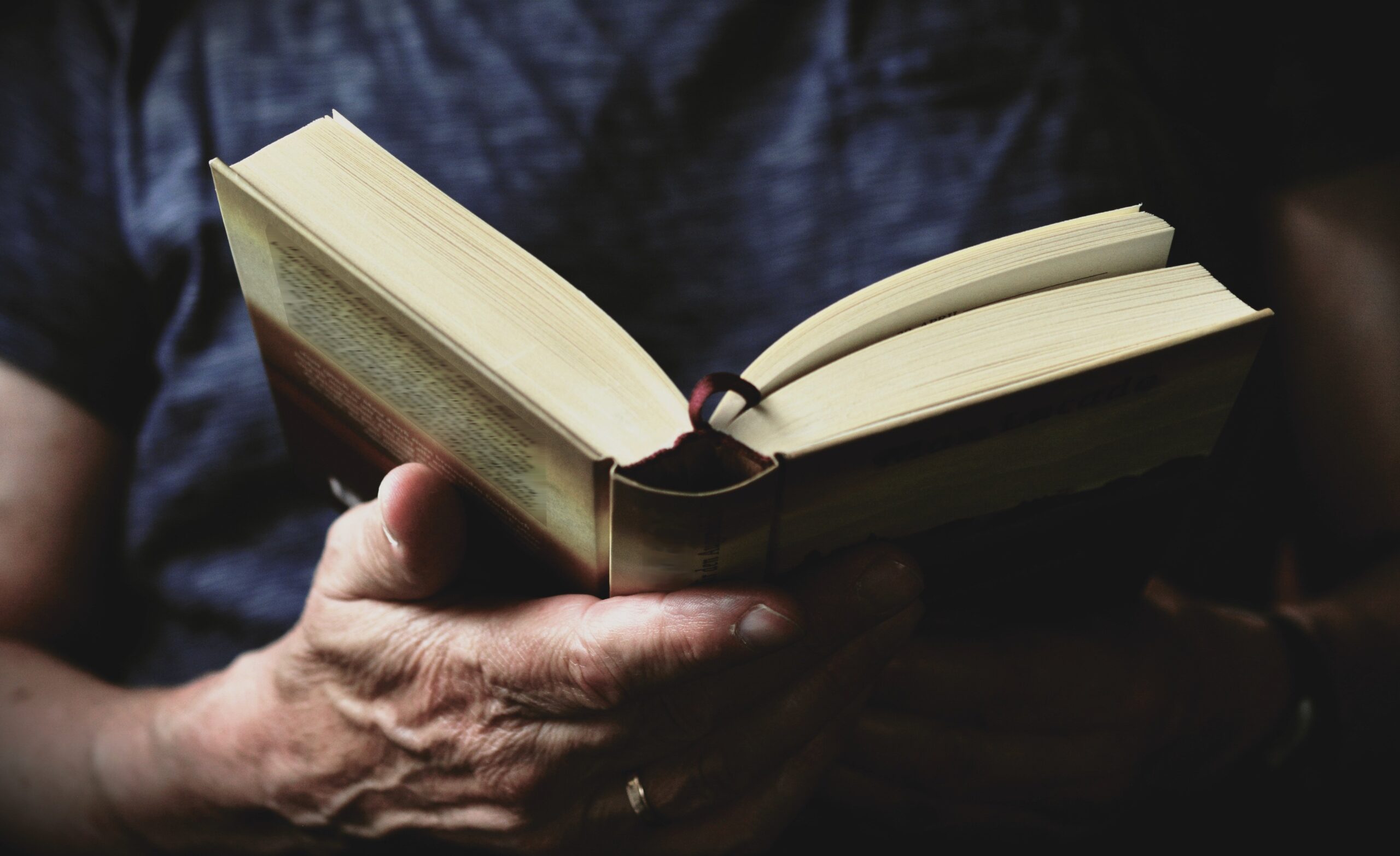 Hombre sosteniendo libro entre manos